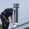 Install storm collar and seal. Install top section of chimney and chimney cap. Paoli, Indiana.