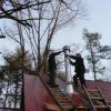 Install top section of chimney, chimney cap, storm collar, and chimney bracing.  Hillham, Indiana.